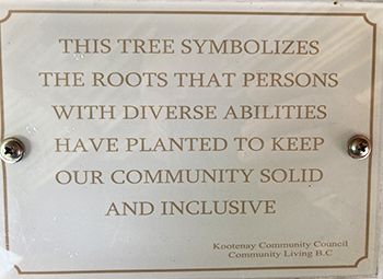 A plaque with the words: “This tree symbolizes the roots that persons with diverse abilities have planted to keep our community solid and inclusive.”
